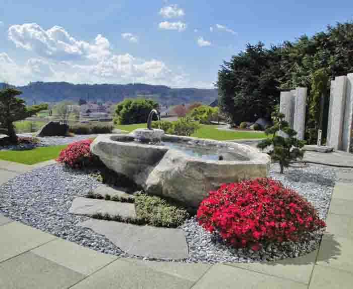 Maggia Granit - Maggia Granit Natursteinbrunnen mit Eisen Einlauf